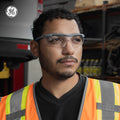 gray/blue, Clear Anti-Scratch | model wearing glasses in industrial setting | Wrap-Around Safety Glasses — GE PPE 01 Series, ANSI Z87.1 | GE101C