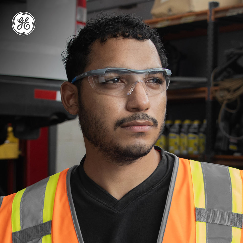 gray/blue, Clear Anti-Scratch | model wearing glasses in industrial setting | Wrap-Around Safety Glasses — GE PPE 01 Series, ANSI Z87.1 | GE101C